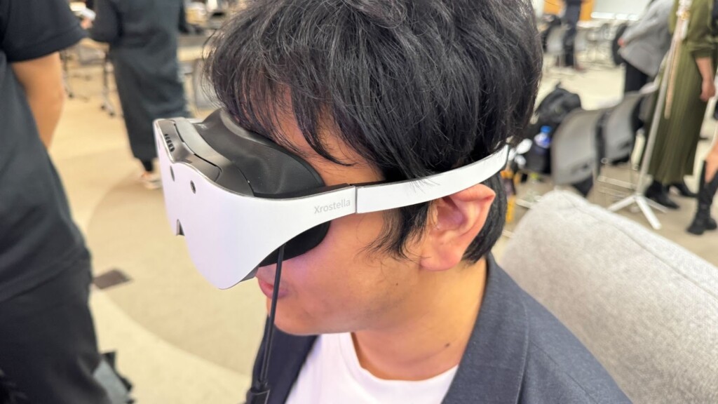 クロステラをかける筆者の画像。メガネ型で弦だけで本体部分を支えられている